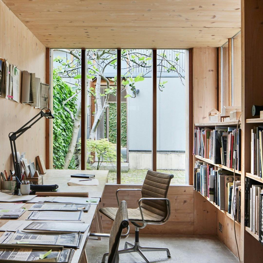 A study boarded with pine and a large window looking out on a garden